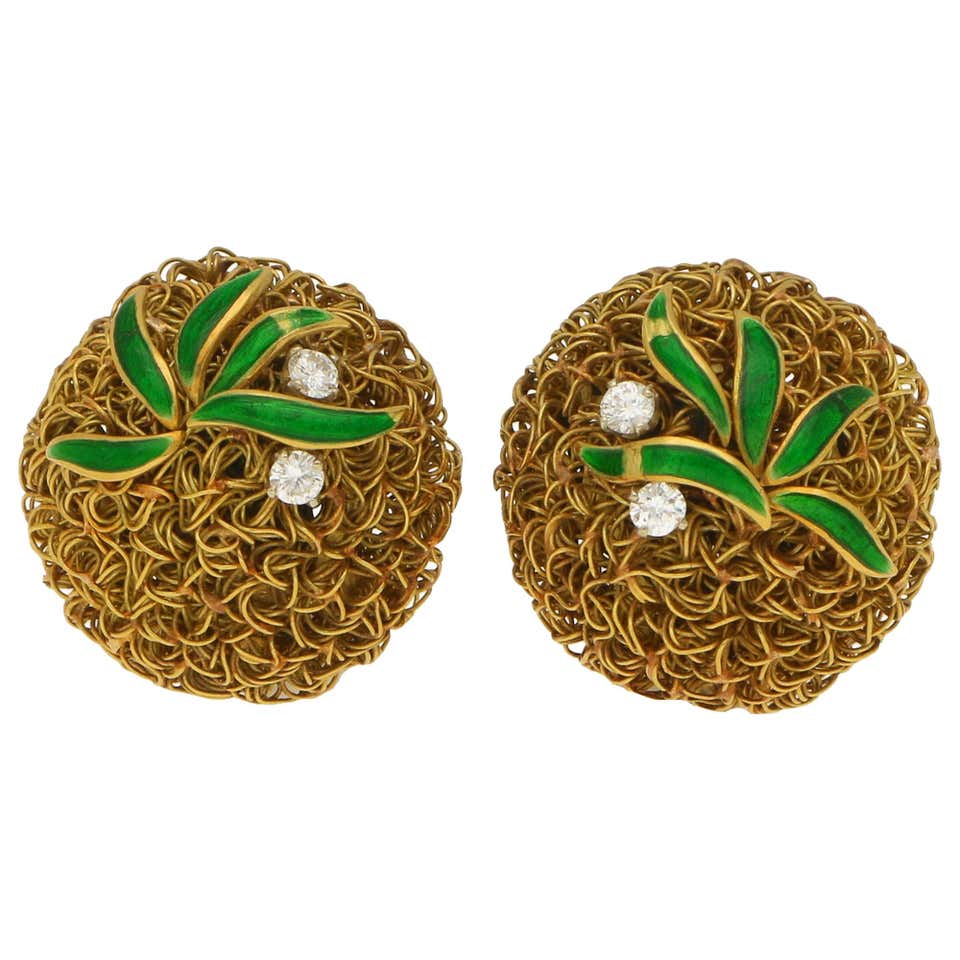 A pair of gold wire work clips earrings set with enamel leaves and diamonds.