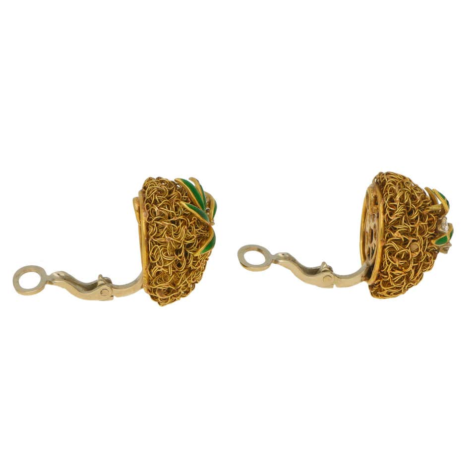 A pair of gold wire work clips earrings set with enamel leaves and diamonds.