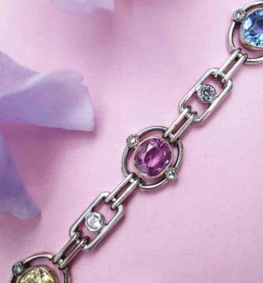 Art Deco Multi Colour Sapphire and Diamond Bracelet; oval links set with a natural facetted oval sapphire; two yellow, two pink and two blue, accented with rose cut diamonds and white sapphires, in silver and gold, Circa 1920