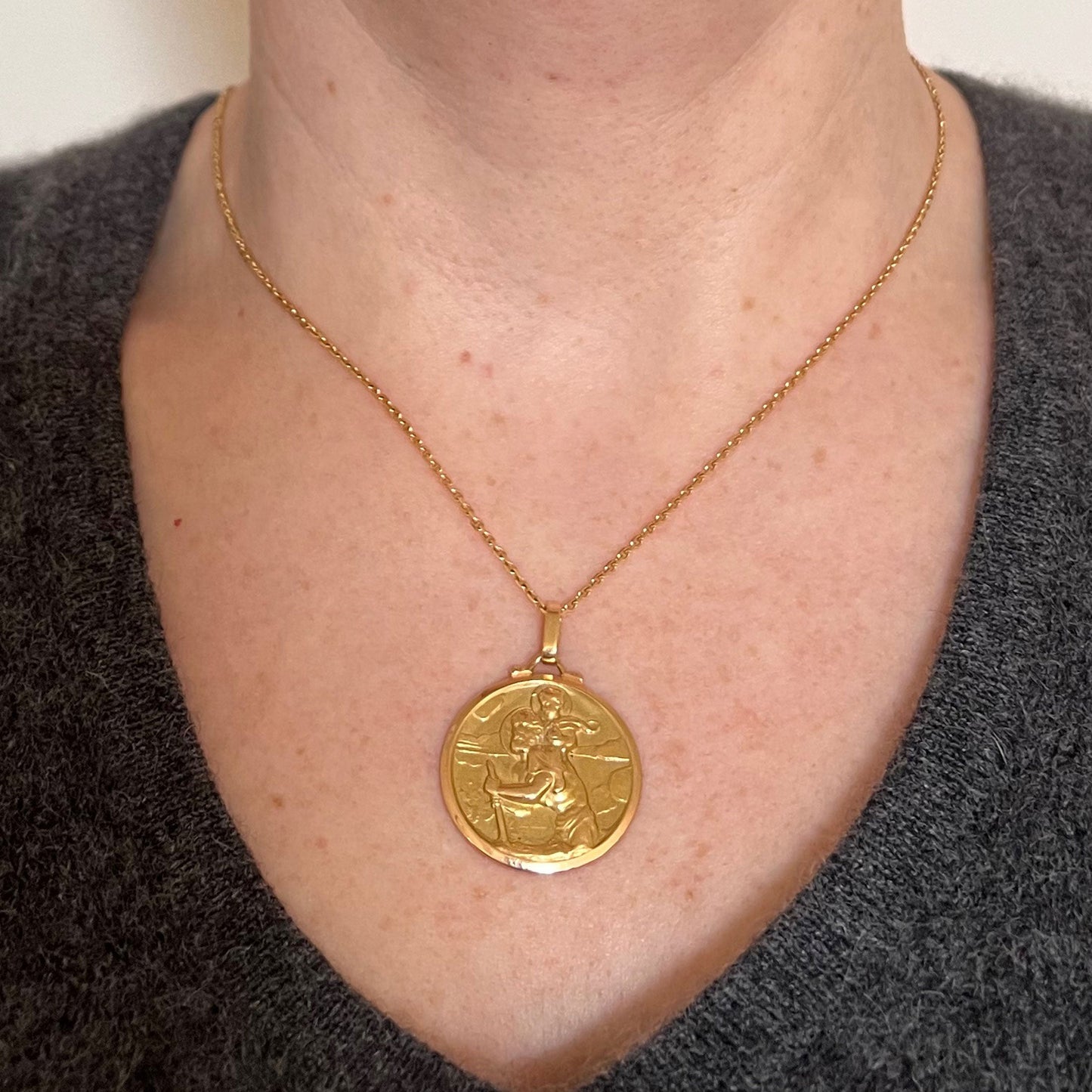 A round yellow gold Saint Christopher pendant, modelled on a gold chain