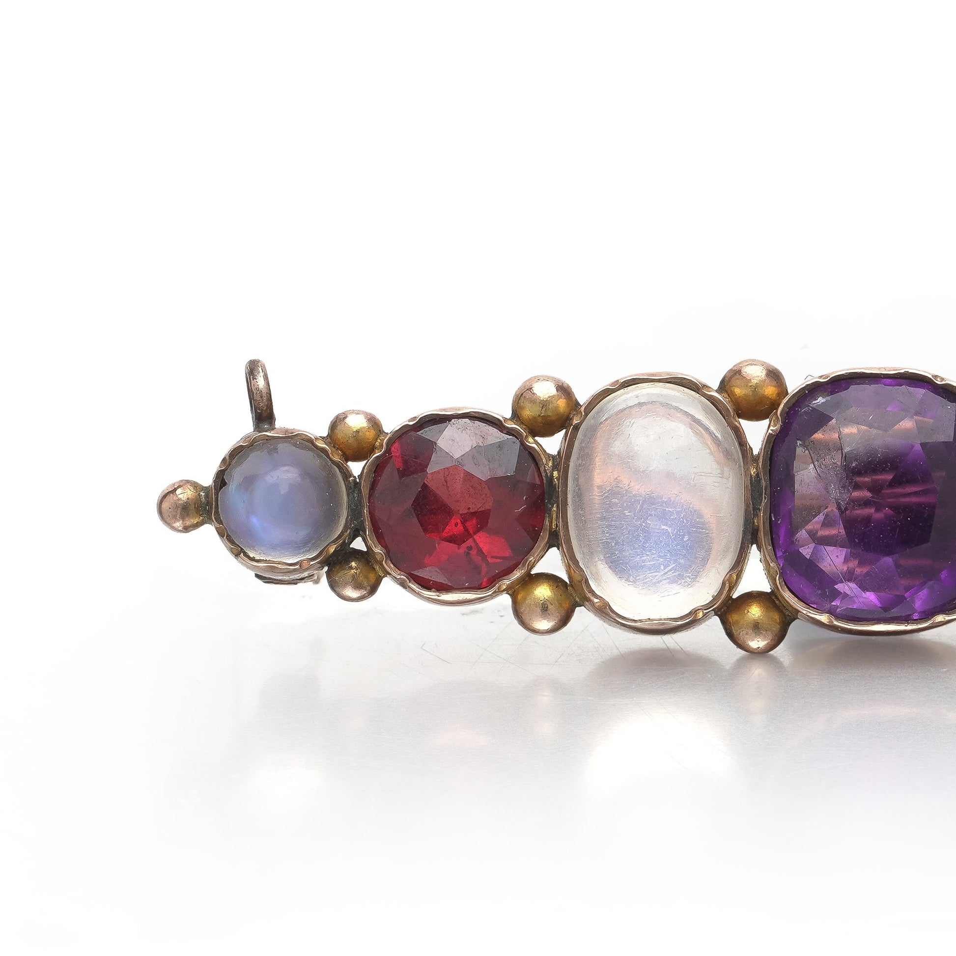 A cabochon multi-gemstone bar brooch in yellow gold