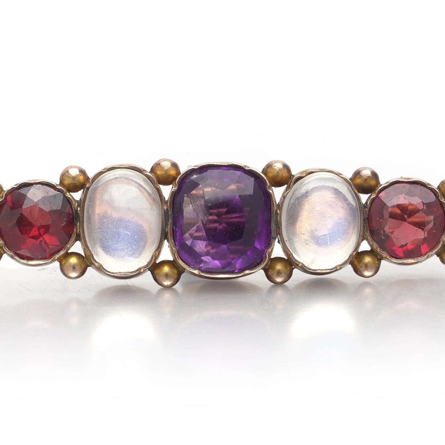 A cabochon multi-gemstone bar brooch in yellow gold