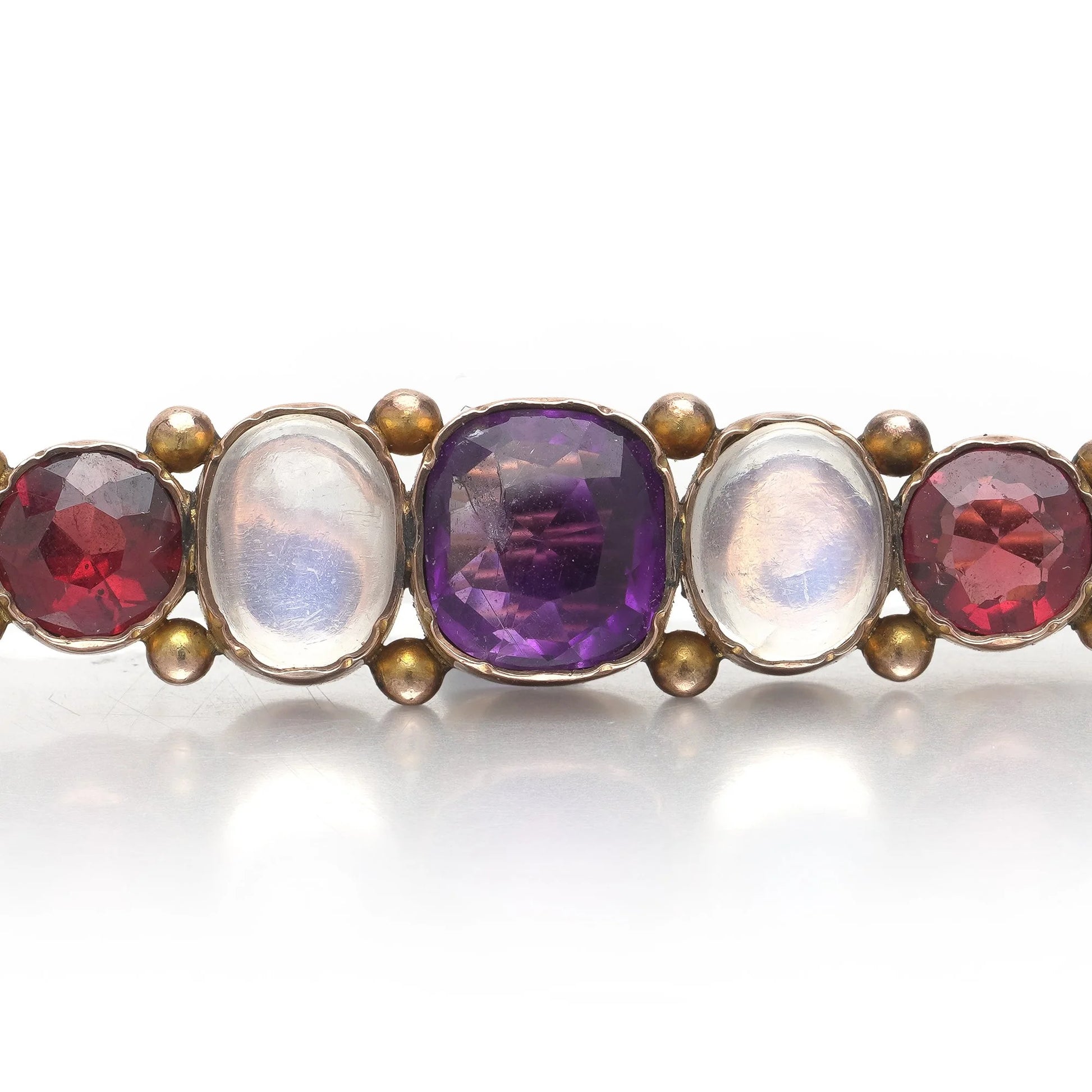 A cabochon multi-gemstone bar brooch in yellow gold