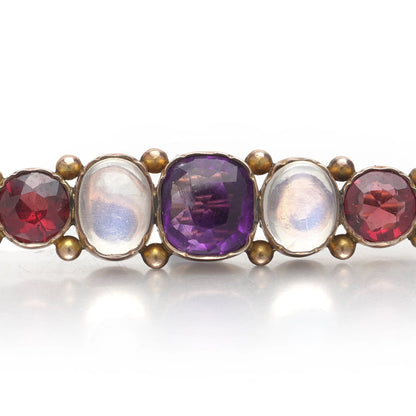 A cabochon multi-gemstone bar brooch in yellow gold