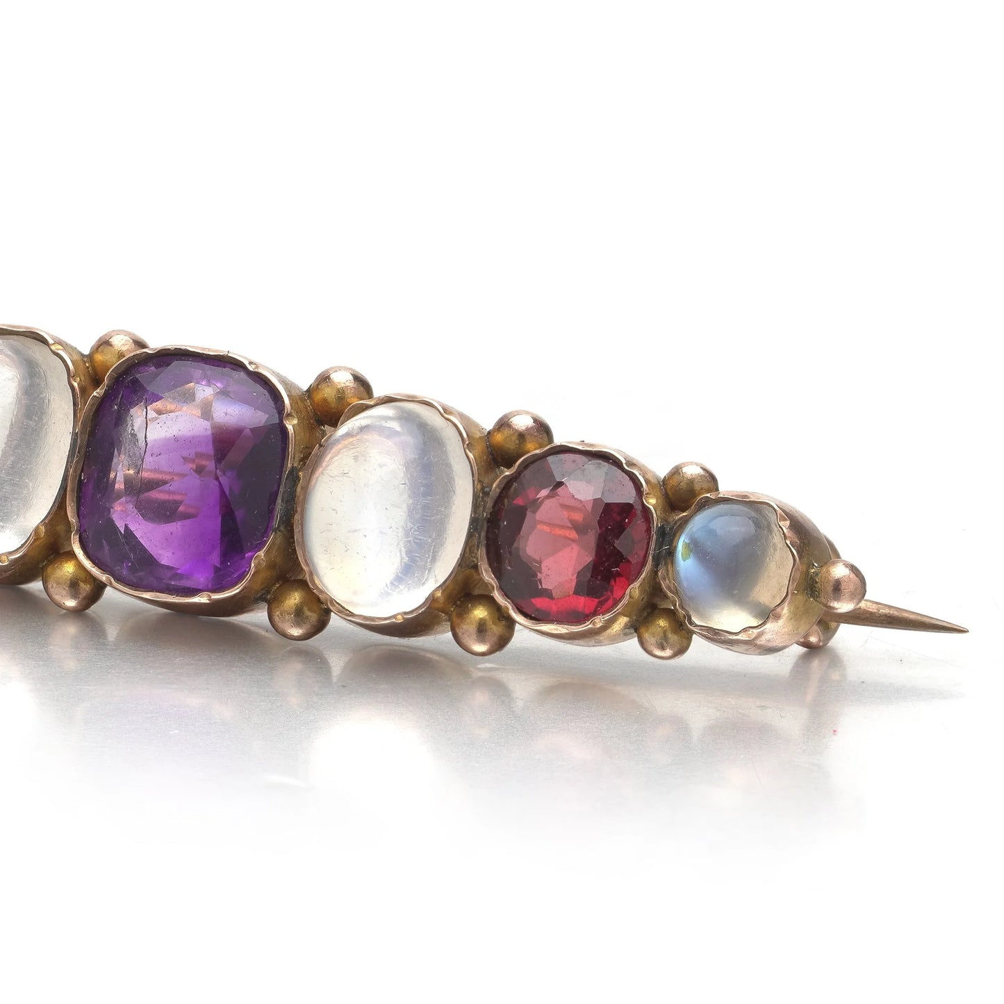 A cabochon multi-gemstone bar brooch in yellow gold