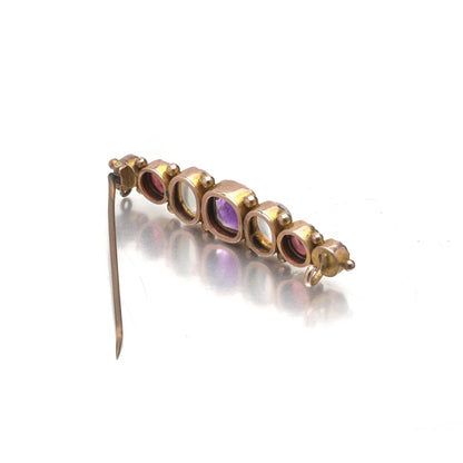 A cabochon multi-gemstone bar brooch in yellow gold