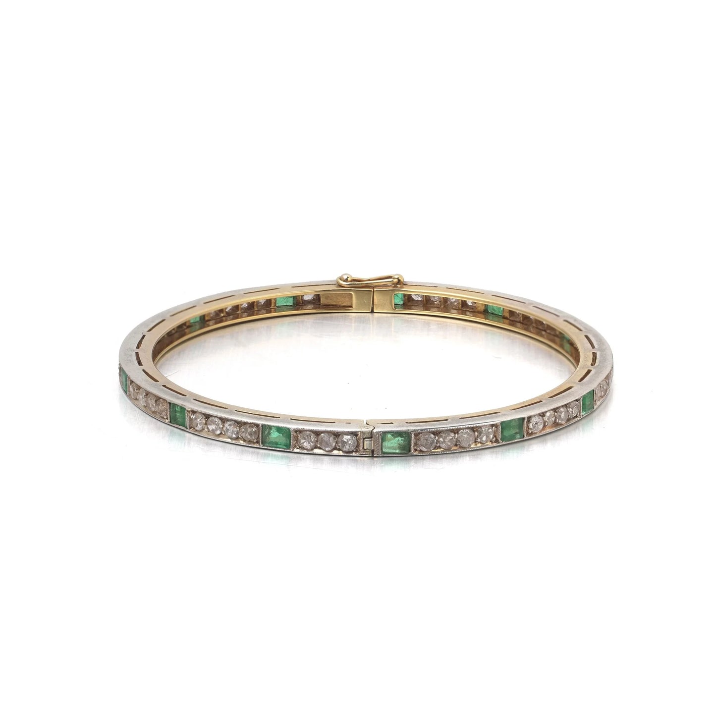 A square emerald and round diamond set bangle bracelet in yellow gold and silver