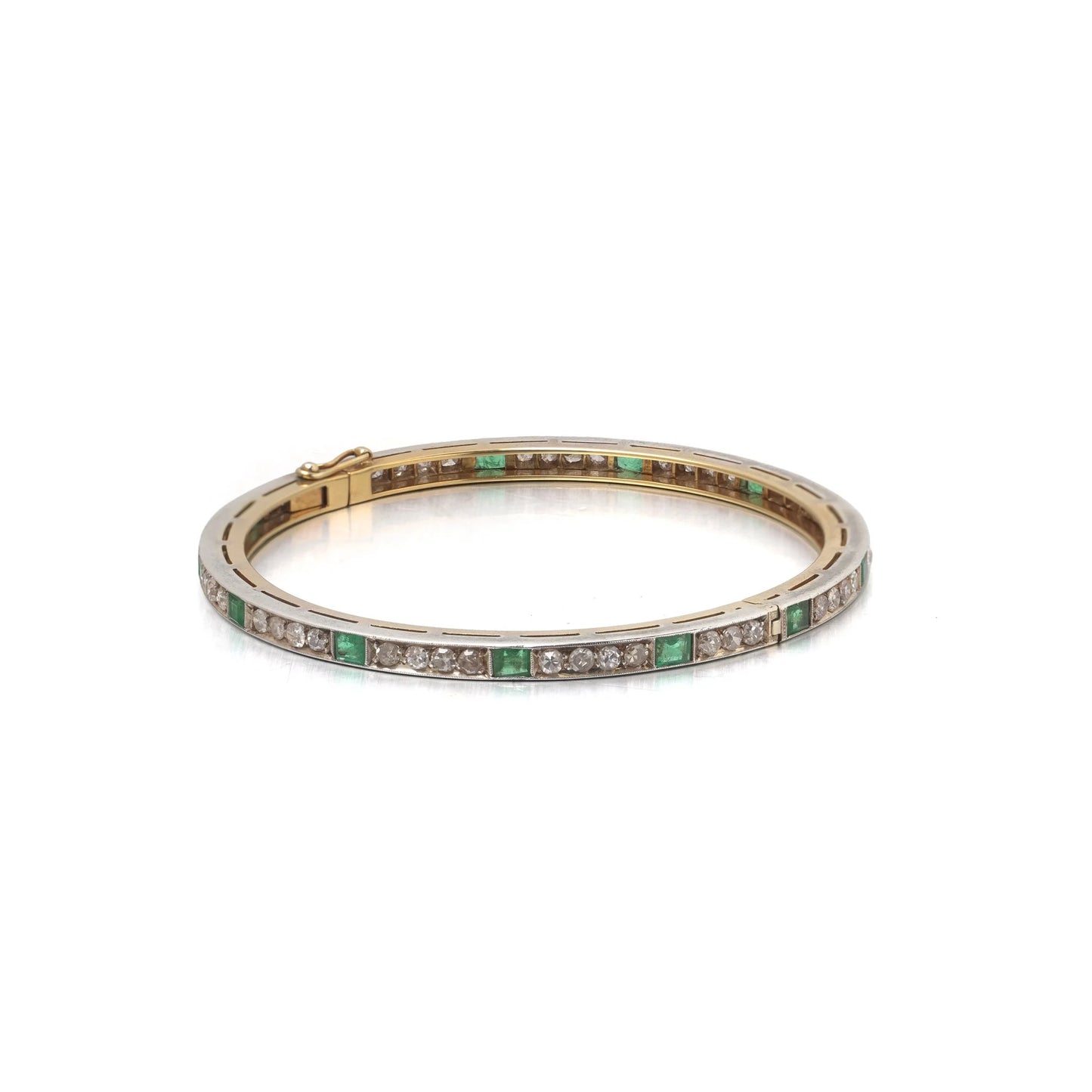 A square emerald and round diamond set bangle bracelet in yellow gold and silver