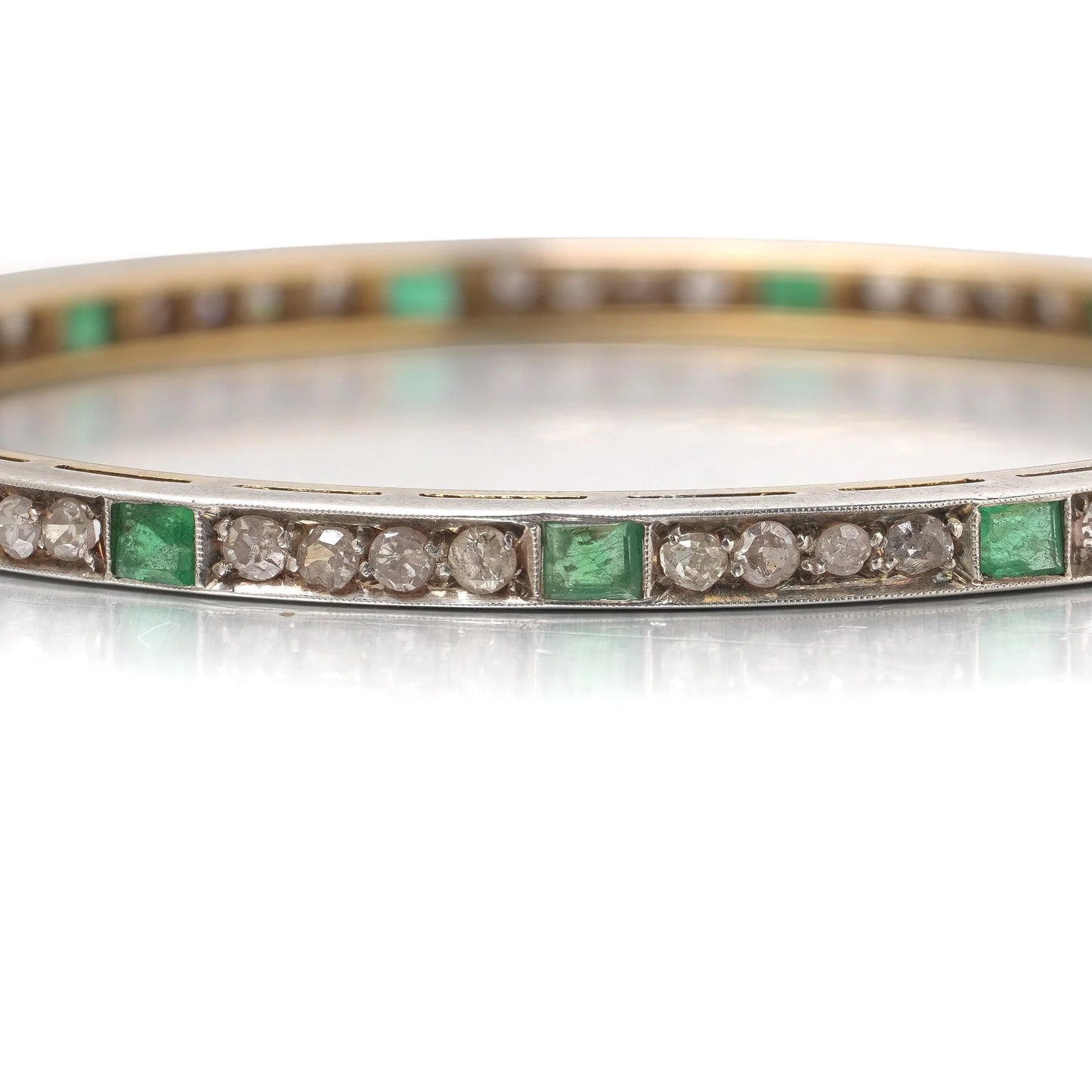 A square emerald and round diamond set bangle bracelet in yellow gold and silver