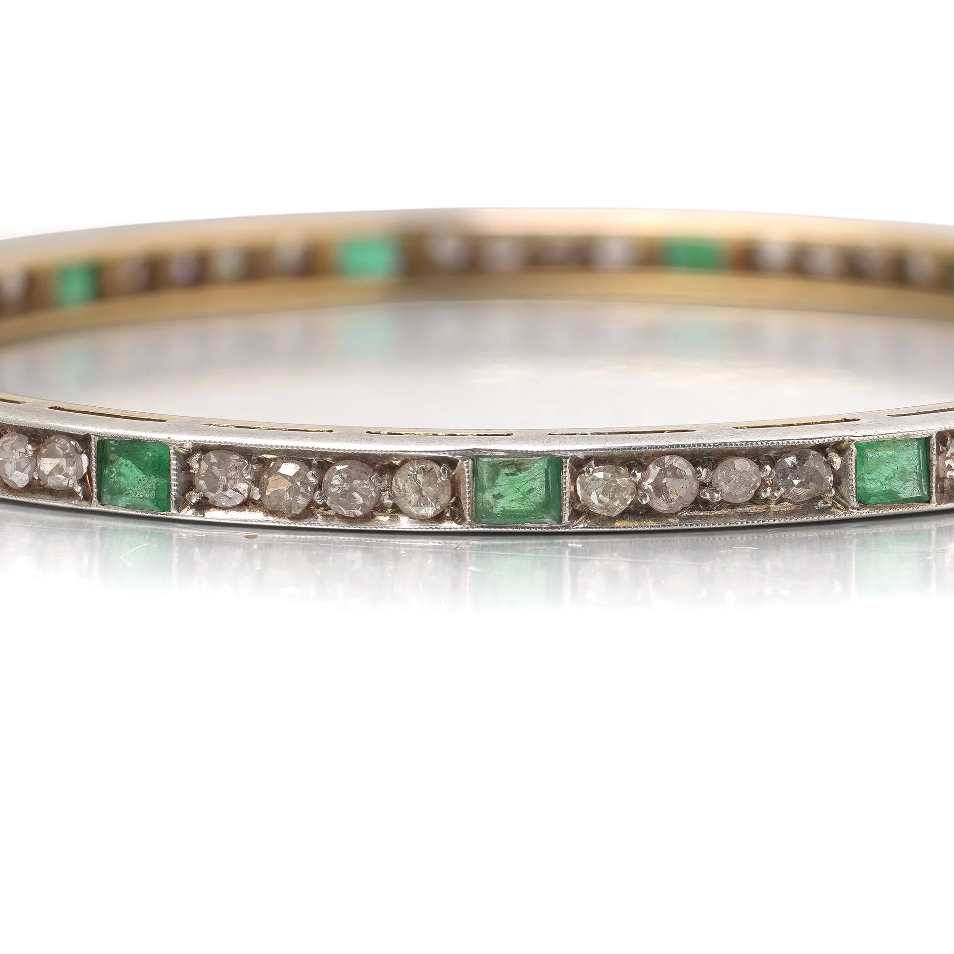 A square emerald and round diamond set bangle bracelet in yellow gold and silver