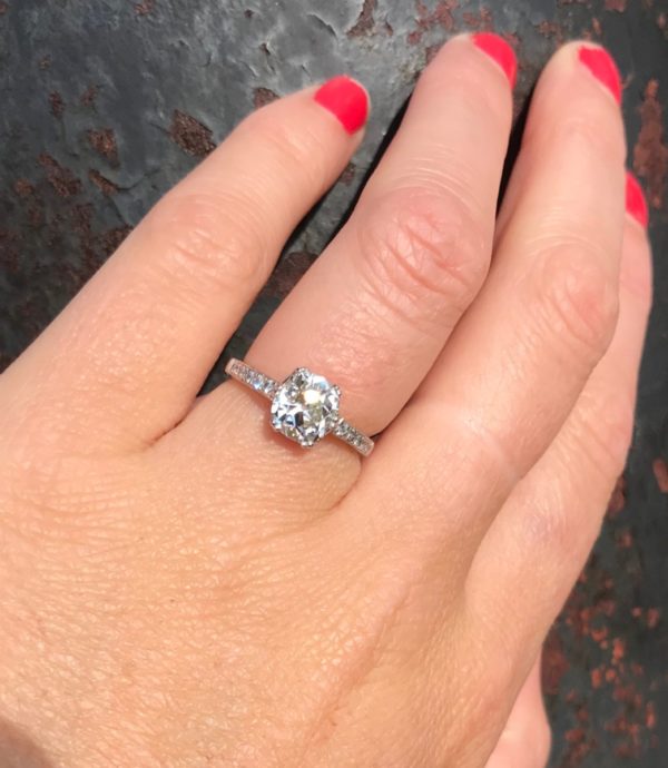 Cushion cut diamond engagement ring on finger