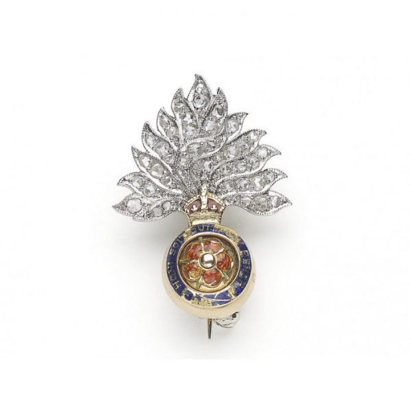 A British Royal Fusiliers badge, with a rose-cut diamond set flame, on white metal, over an enamelled crown, surmounting a blue enamelled garter, inscribed HONI SOIT QUI MAL Y PENSE, surrounding an enamelled red rose on yellow gold.