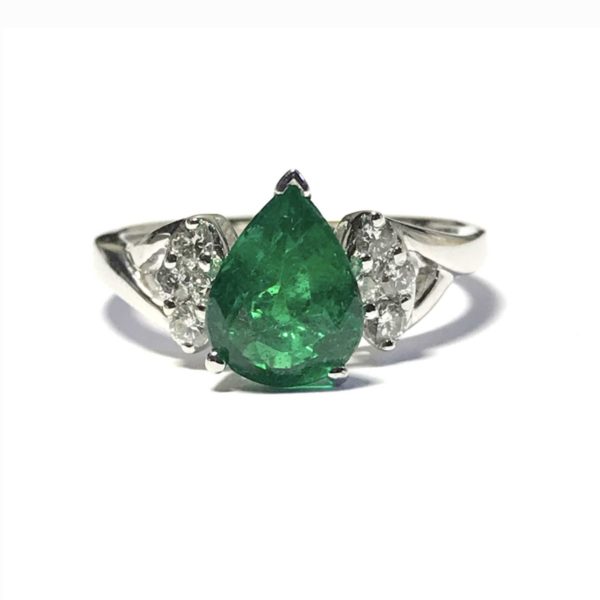 Emerald and diamond cluster ring, the pear shape emerald weighing 1.39 carats in a three claw setting with round brilliant cut diamonds to each shoulder, mounted in 18ct white gold. 