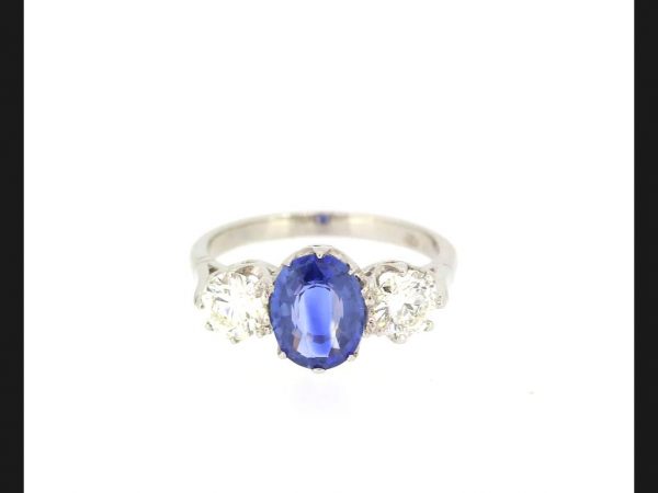 Classic sapphire and diamond three stone ring; Central oval cut 2.14 carat Sapphire flanked by two round cut diamonds totaling 1.20 carats, Set in Platinum