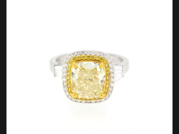 4.02 carat central cushion cut yellow diamond within a double halo of yellow and white round cut diamonds, with baguette shoulders.