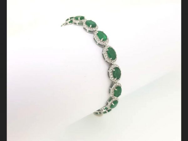 Emerald & Diamond Bracelet; Oval cut emeralds encircled by round cut diamonds, set on 18ct white gold flexible bracelet. (Emeralds 4.29ct, diamonds 1.48ct)