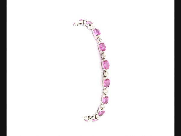 Pink Sapphire & Diamond Bracelet; Oval cut pink sapphires (8.60 ct total) interspersed with round cut diamonds (0.50ct total), set in 18ct white gold