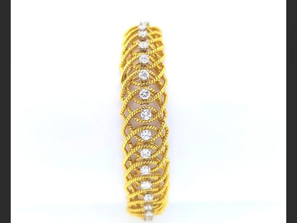 A flexible golden rope twist design bracelet with central diamonds totaling an estimated 2.50 carats