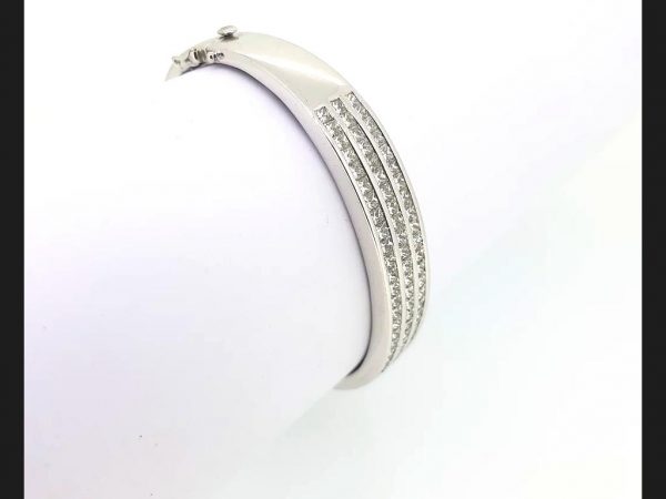 Triple row of  princess cut diamonds channel set into solid 18ct white gold hinged bangle. Diamond total weight: 4.80 carats