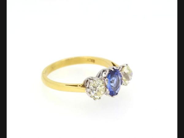 Classic sapphire and diamond trilogy ring; Central oval cut Sapphire flanked by two round cut diamonds