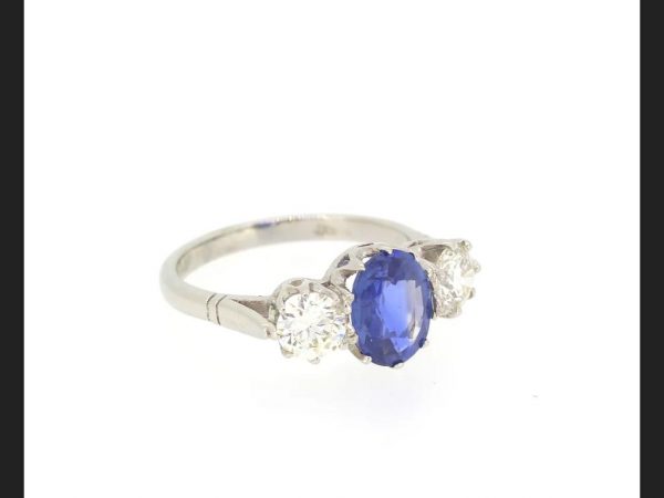 Classic sapphire and diamond trilogy ring; Central oval cut 2.14 carat Sapphire flanked by two round cut diamonds totaling 1.20 carats, Platinum