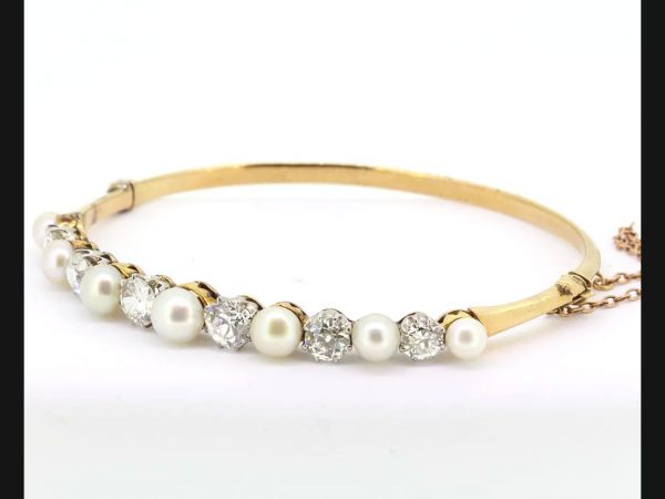 Edwardian hinged bangle set with natural pearls and diamonds, in 18ct yellow gold and platinum.