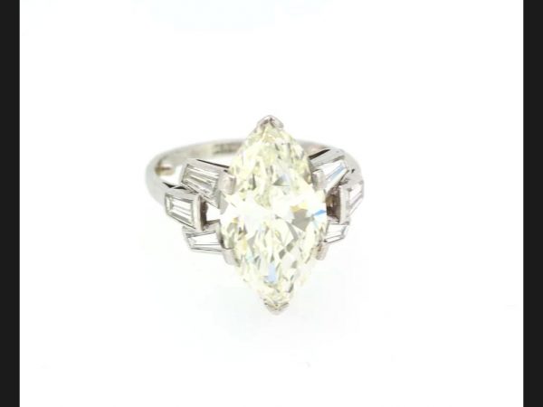 Vintage Marquise Diamond Ring; central 5.10 carat Marquise cut diamond flanked by tapered baguette diamond shoulders, in Platinum, Circa 1950