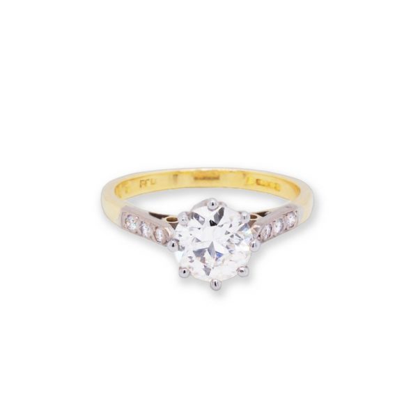 Diamond Solitaire Engagement Ring; a 1.15 carat round cut diamond is flanked by three diamonds set into the shoulders on either side, 18ct yellow gold.