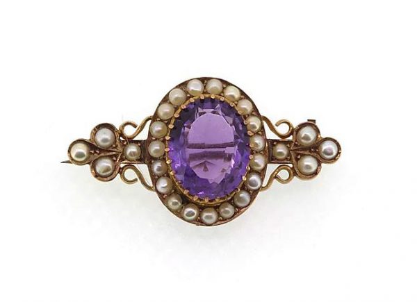 Antique Victorian Amethyst and Pearl Cluster Brooch; A pretty brooch set with an oval-faceted amethyst and split pearls. Mounted in high carat gold.