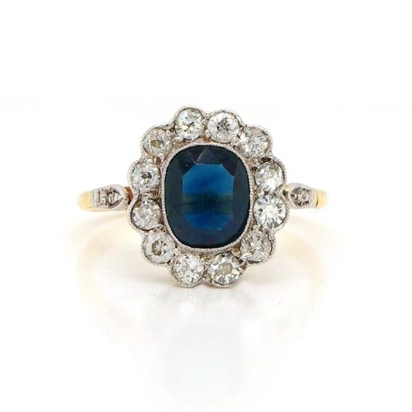 Antique Edwardian Sapphire and Old Cut Diamond Cluster Ring; featuring a cushion shaped sapphire surrounded by 0.40cts old-cut diamonds, 18ct yellow gold