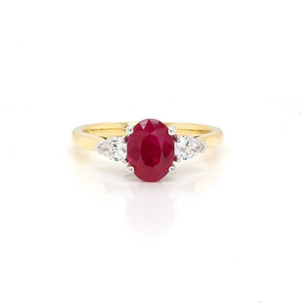 Oval Cut Ruby and Diamond Three Stone Ring; 0.88ct oval-cut ruby flanked by pear-shaped diamonds totalling 0.54cts. Mounted on an 18ct yellow gold shank.