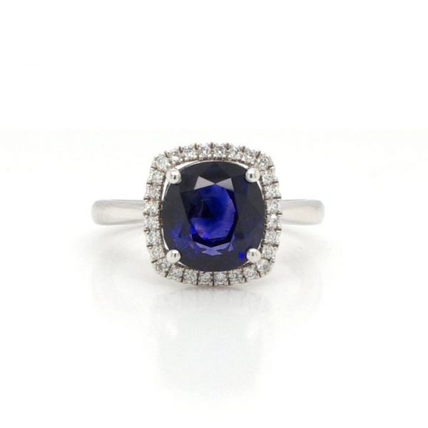 Cushion Cut Sapphire and Diamond Cluster Ring, 3.53 carat cushion-cut sapphire, four-claw set, surrounded by diamonds and mounted on a plain platinum shank.
