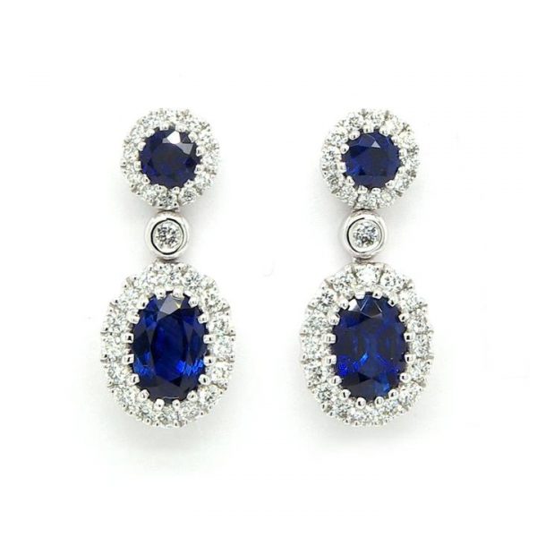 Pair of 1.32ct Sapphire and Diamond Cluster Drop Earrings; round sapphire within diamond surround suspending an oval sapphire cluster drop, 18ct white gold