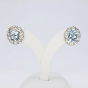Aquamarine and Diamond Oval Cluster Earrings; 2.50cts oval aquamarines surrounded by 1.90cts round brilliant-cut diamonds, in 18ct white gold
