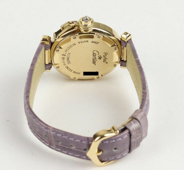 Cartier Pasha de Cartier 18ct Yellow Gold 2399 Ladies Automatic 32mm Wrist Watch With Removable Diamond Grill, white textured dial, Arabic numerals at 12, 3, 6 and 9 o'clock, sapphire crystal glass and a pavé set diamond crown cap. On a Cartier purple leather strap, with a Cartier 18ct yellow gold pin buckle.