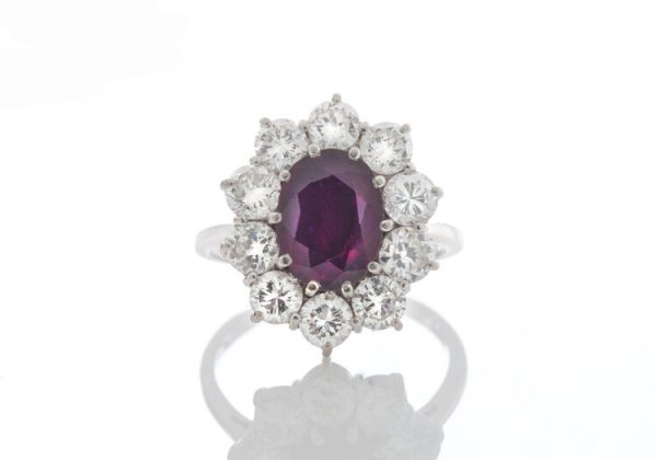 Vintage 1.5ct Thai Ruby and Diamond Cluster Ring in 18ct White Gold; 1.50 carat oval ruby surrounded by 1.00cts sparkling diamonds, in 18ct white gold. Circa 1970's.