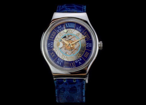 Swatch Tresor Magique Platinum 36mm Automatic Wrist Watch, golden face with celestial detailing, Roman numeral markers on outer blue band, blue leather strap, Circa 2000's