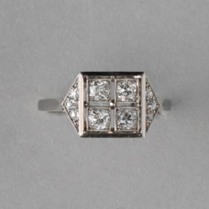 Art Deco French 0.70ct Old Cut Diamond and Platinum Square Ring; four old cut diamonds, flanked by diamond-set triangle shoulders, Numbered, Circa 1920
