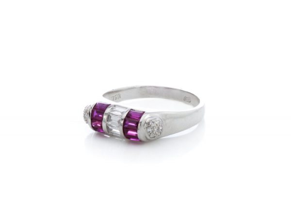 Contemporary Ruby and Diamond Dress Ring; central vertical strip of baguette-cut diamonds flanked by lines of baguette-cut rubies and cluster of round brilliant-cut diamonds to each tapered shoulder, 18ct white gold