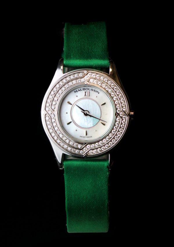Mauboussin Ladies 18ct Gold and Diamond 26mm Quartz Watch, 18ct gold case, 1.00ct diamond bezel, on a green Mauboussin fabric strap.