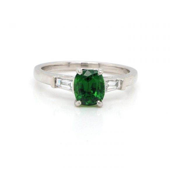 Green Tsavorite Garnet, Diamond and Platinum Solitaire Ring; 1.28ct oval tsavorite garnet with a baguette diamond set to each shoulder