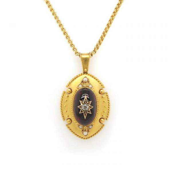 Antique Victorian Ornate Cabochon Garnet and Gold Pendant; large cabochon garnet with central diamond set star and shield-shaped, rope-edged surround. 19th century, Circa 1880