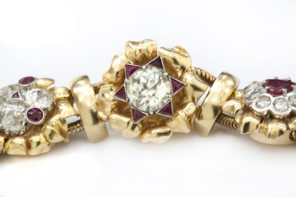 Vintage 7ct Diamond and Ruby Cluster Bracelet; set with 7.00 carats of diamonds and 3.00 carats of rubies in intricate and unique floral clusters surrounded by gold leaves, in 18ct yellow gold, Circa 1930s