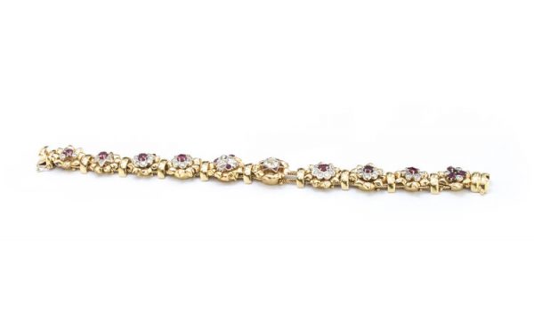 Vintage 7ct Diamond and Ruby Cluster Bracelet; set with 7.00 carats of diamonds and 3.00 carats of rubies in intricate and unique floral clusters surrounded by gold leaves, in 18ct yellow gold, Circa 1930s