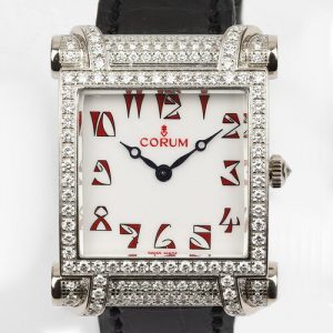 Corum Tabogan 18ct White Gold Watch; 18ct white gold case encrusted with diamonds, white dial with red Arabic numerals, Quartz movement, on Corum black leather strap with 18ct white gold buckle