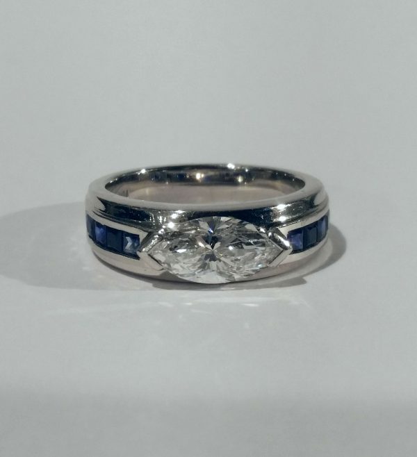 Vintage Marquise Diamond and Sapphire Band Ring; set with a 1.25ct marquise cut diamond with square cut sapphire shoulders, in platinum, Circa 1980s