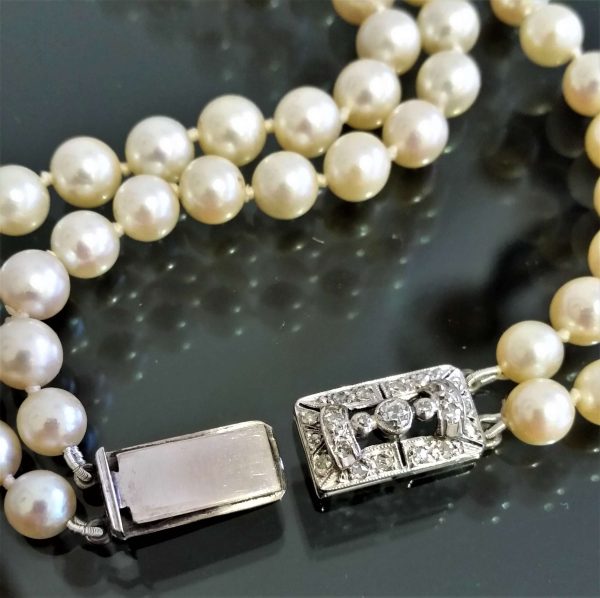 Vintage Akoya Pearl Two Row Necklace with Diamond Clasp; graduated double row of Akoya cultured pearls on a platinum and white gold clasp set with 0.25cts old cut diamonds, Circa 1940s