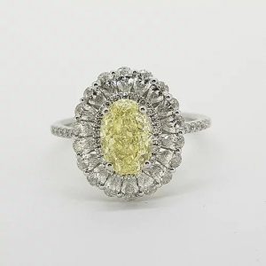 Fancy Yellow Diamond Cluster Ring with GIA Certificate; 1.59ct Oval Fancy Yellow GIA certified Natural Diamond surrounded by 0.15cts brilliant white diamonds and an outer border of 0.90cts pear-shaped diamonds, giving a scalloped edge finish, mounted in platinum