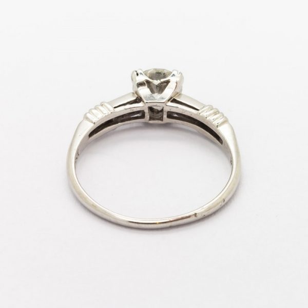 Vintage 0.61ct Diamond Engagement Ring in Platinum; single stone diamond ring featuring a 0.61 carat round brilliant-cut diamond, four claw set, with diamond set shoulders. Circa 1940. Accompanied by a diamond certificate