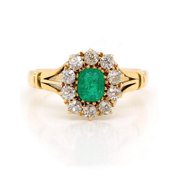 Vintage Emerald and Diamond Cluster Ring; central oval emerald is within a surround of ten diamonds, in 18ct yellow gold with split belted shoulders, Circa 1930s